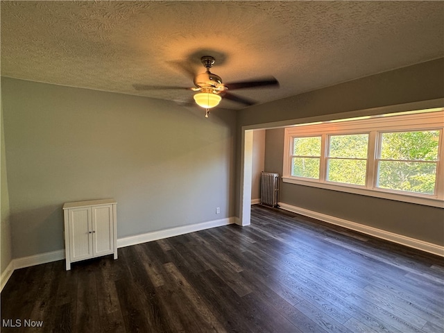 spare room with a textured ceiling, radiator, dark hardwood / wood-style floors, and ceiling fan