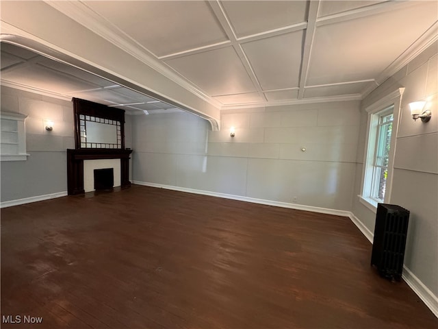 unfurnished living room featuring radiator, dark hardwood / wood-style floors, a fireplace, and crown molding