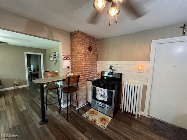 kitchen with radiator, stainless steel electric range oven, ceiling fan, and dark hardwood / wood-style flooring