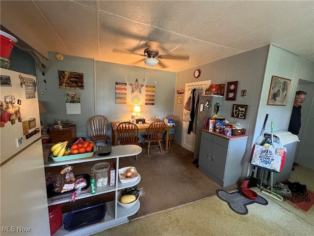 carpeted dining room with ceiling fan