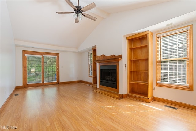 unfurnished living room with lofted ceiling with beams, ceiling fan, plenty of natural light, and hardwood / wood-style floors