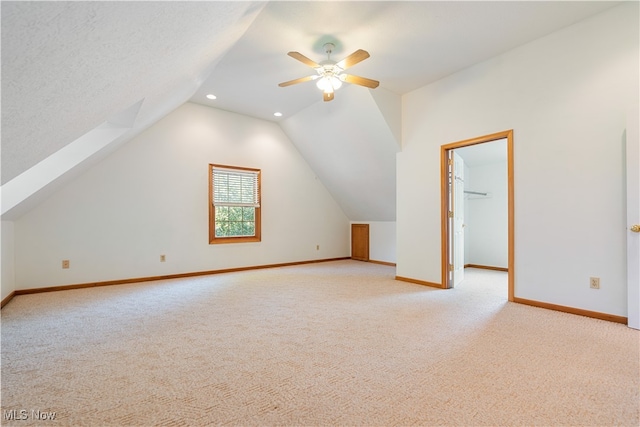 bonus room featuring a textured ceiling, lofted ceiling, ceiling fan, and light colored carpet