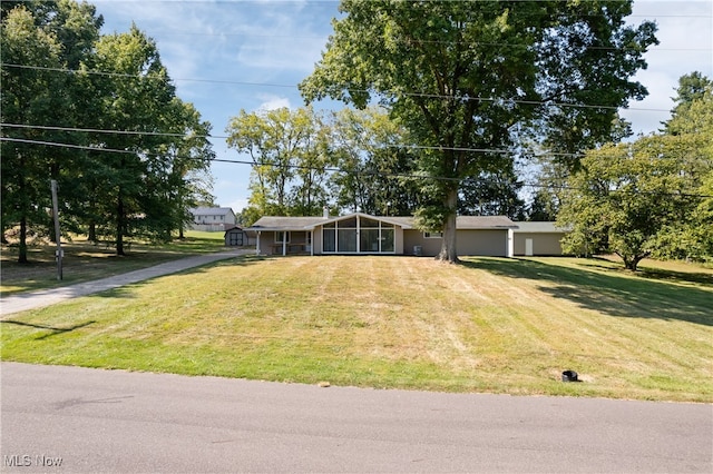 single story home featuring a front yard and a sunroom