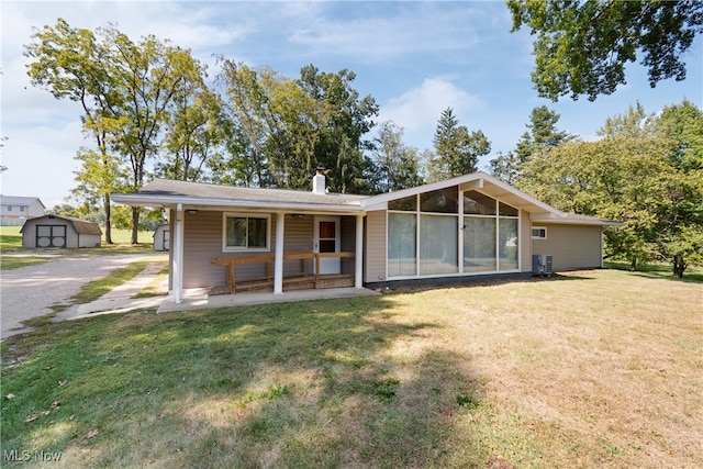 view of front of home featuring a storage unit, central AC, and a front yard