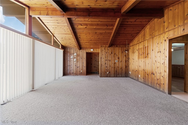 empty room with wood ceiling, wooden walls, vaulted ceiling with beams, and carpet floors