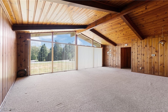 spare room with vaulted ceiling with beams, wood walls, carpet, and wooden ceiling