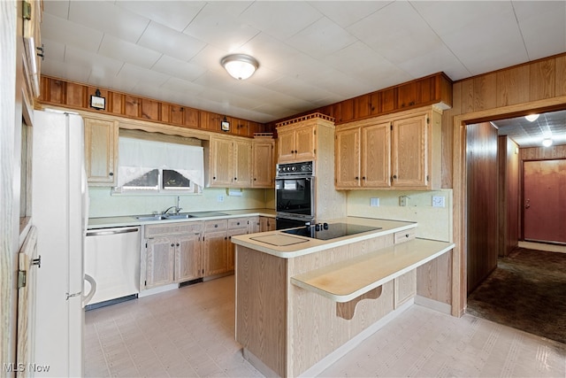 kitchen with a kitchen breakfast bar, kitchen peninsula, wood walls, light brown cabinets, and black appliances