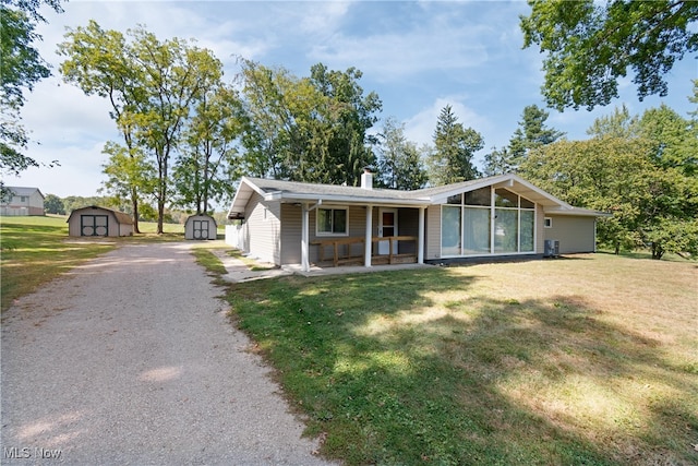 single story home featuring a storage unit, a front lawn, and a patio area