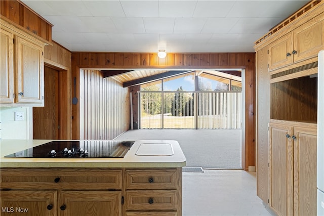 kitchen with black electric cooktop, wooden walls, and lofted ceiling