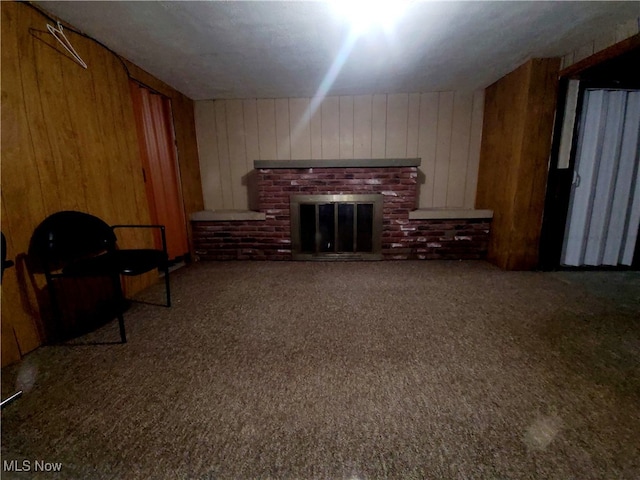 carpeted living room featuring a fireplace and wooden walls