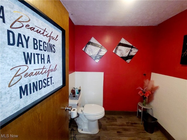 bathroom featuring a textured ceiling, toilet, and hardwood / wood-style flooring