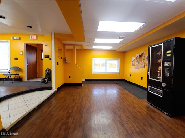 interior space featuring wood-type flooring, elevator, and a paneled ceiling