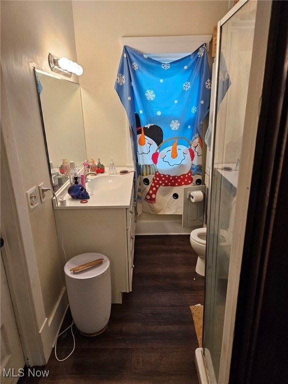 bathroom featuring a shower, toilet, vanity, and hardwood / wood-style flooring