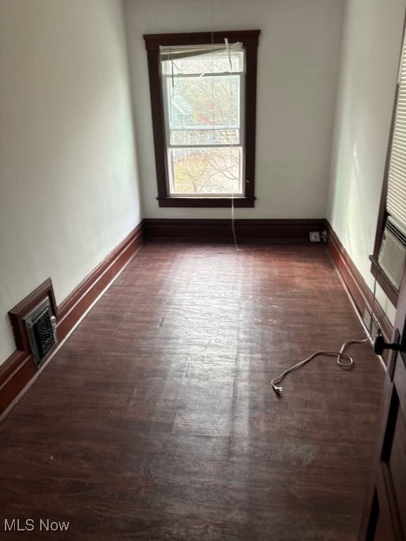 unfurnished room with dark hardwood / wood-style flooring