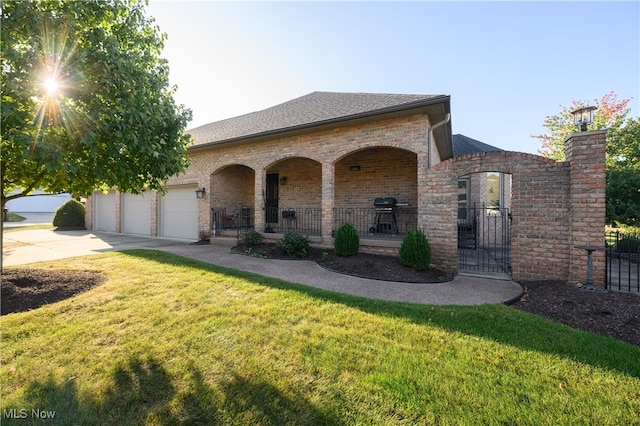 view of front of property featuring a porch, a garage, and a front yard