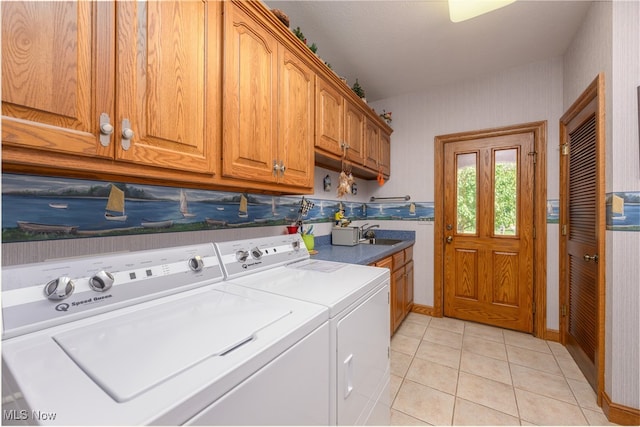 washroom featuring separate washer and dryer, sink, light tile patterned floors, and cabinets