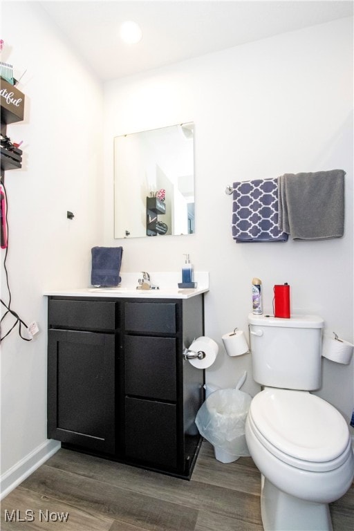 bathroom with vanity, toilet, and hardwood / wood-style flooring