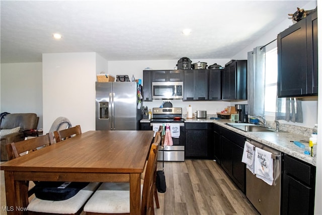 kitchen with stainless steel appliances, light hardwood / wood-style floors, a textured ceiling, and sink