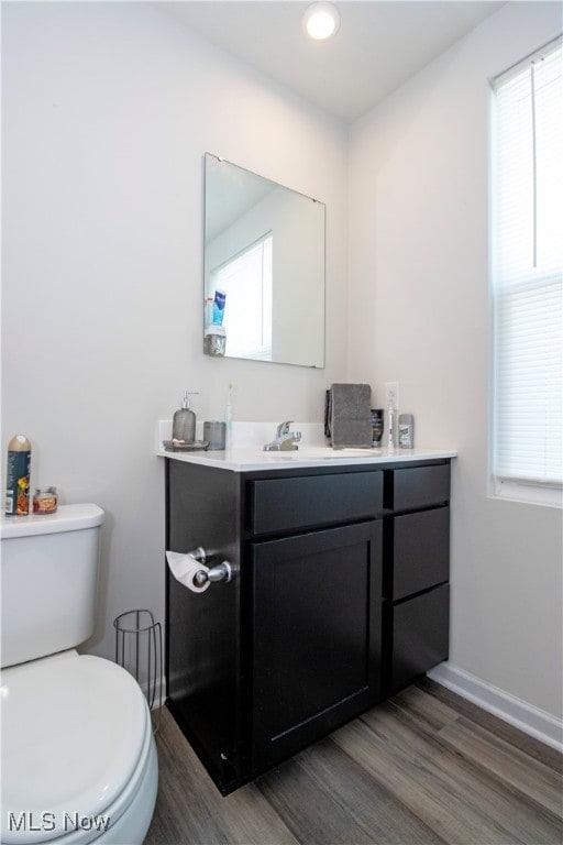 bathroom featuring wood-type flooring, vanity, and toilet