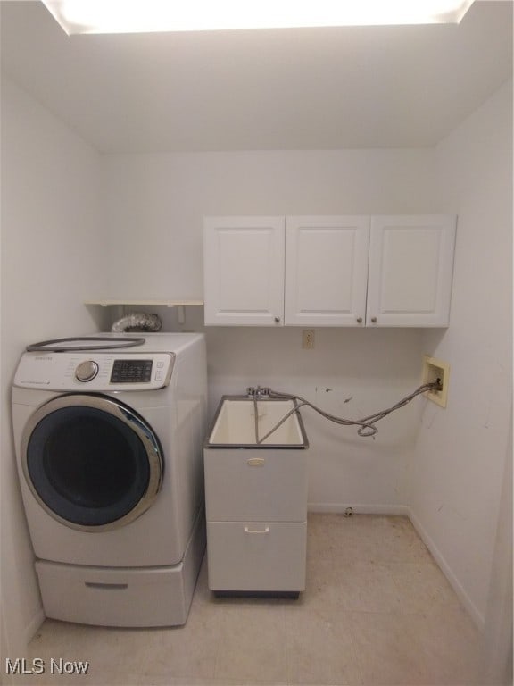 clothes washing area featuring cabinets and washer / clothes dryer