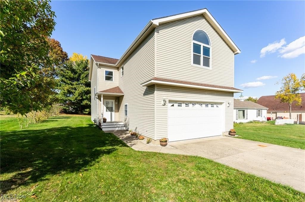 view of property featuring a garage and a front yard