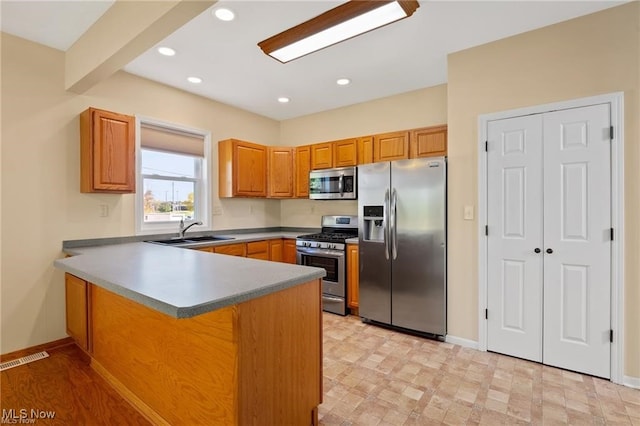 kitchen with kitchen peninsula, sink, and stainless steel appliances