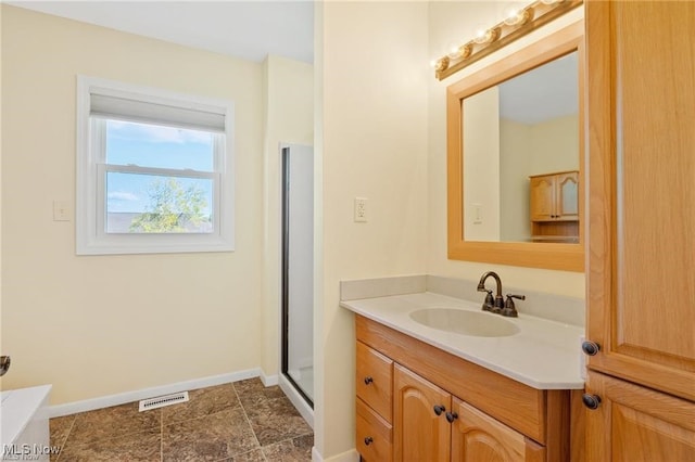 bathroom featuring vanity and a shower with shower door