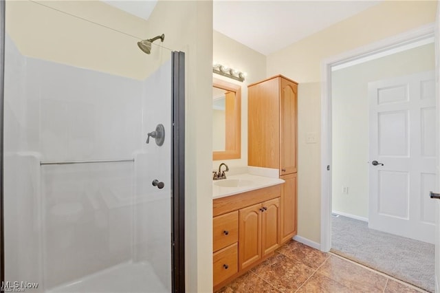 bathroom with tile patterned floors, vanity, and walk in shower