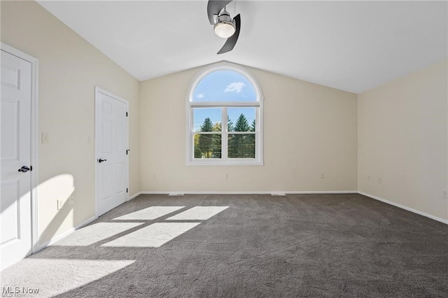 unfurnished bedroom with dark carpet, vaulted ceiling, and ceiling fan