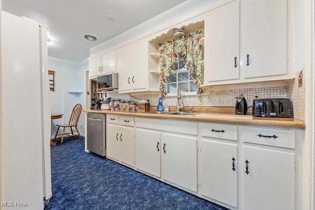 kitchen featuring decorative backsplash, white cabinetry, appliances with stainless steel finishes, and sink