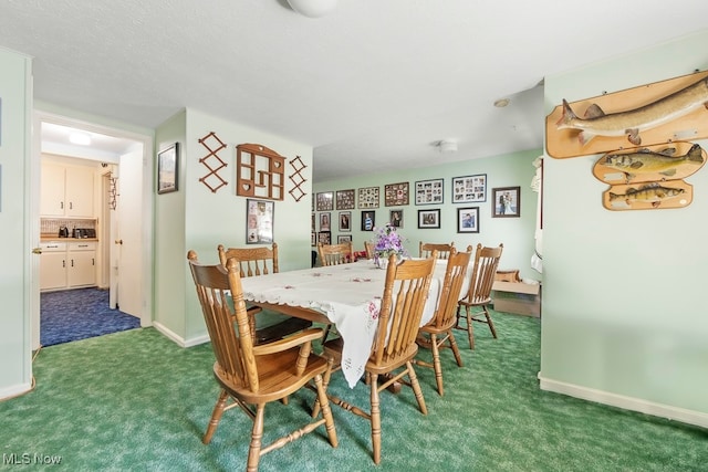 carpeted dining room with a textured ceiling