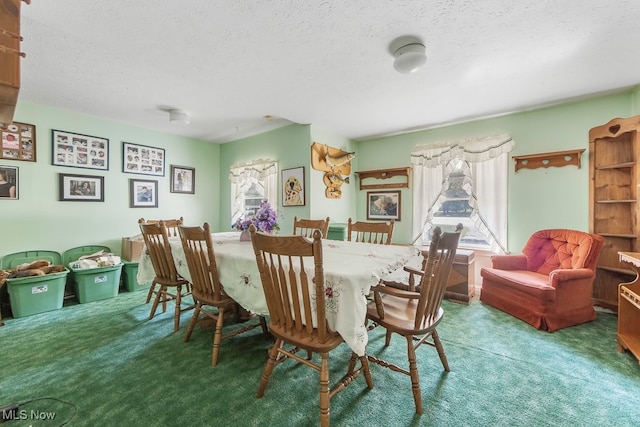 dining space with carpet floors and a textured ceiling