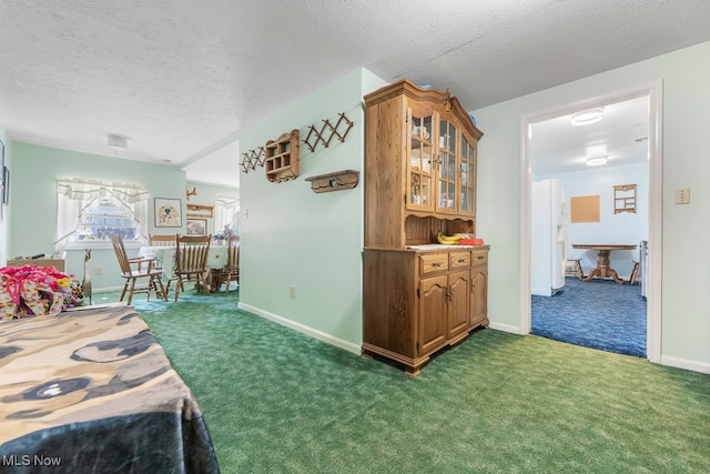 kitchen with a textured ceiling and dark colored carpet