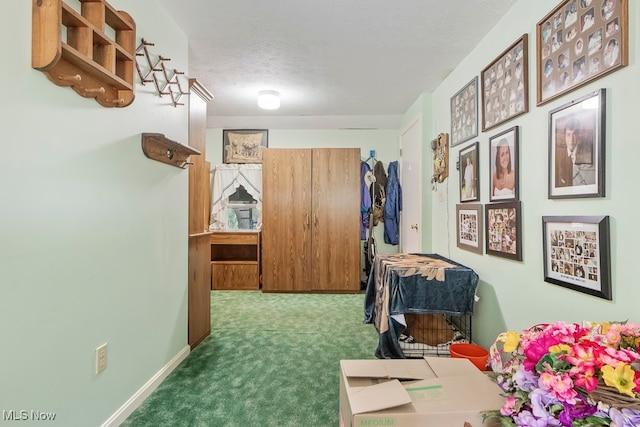 interior space with a textured ceiling and dark colored carpet