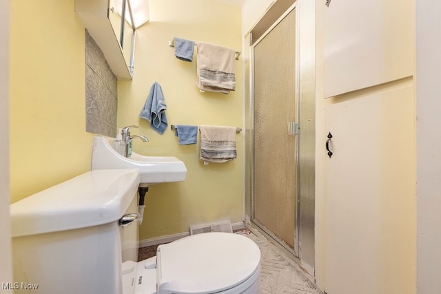 bathroom with sink, walk in shower, and toilet