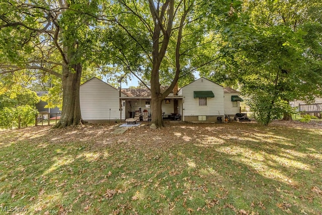 rear view of house featuring a lawn