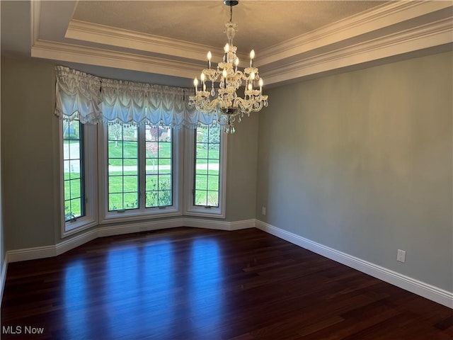 spare room featuring crown molding, a tray ceiling, and baseboards