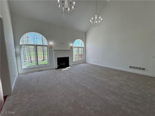 unfurnished living room featuring visible vents, high vaulted ceiling, baseboards, a notable chandelier, and carpet