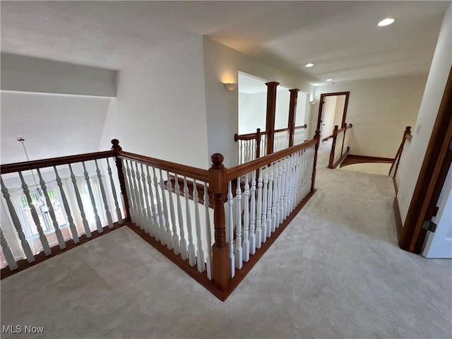 hall featuring carpet floors, baseboards, recessed lighting, and an upstairs landing