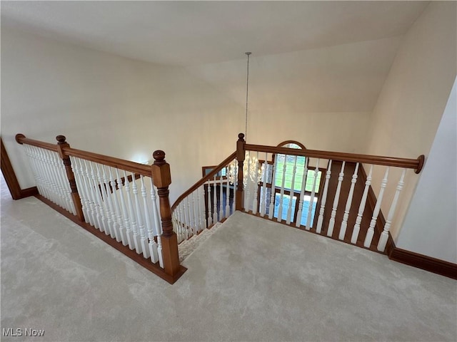 stairway featuring carpet flooring, baseboards, and lofted ceiling