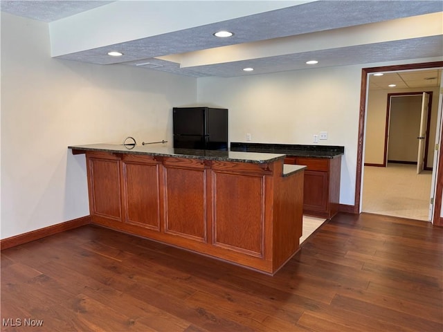 bar featuring baseboards, freestanding refrigerator, dark wood-type flooring, and recessed lighting