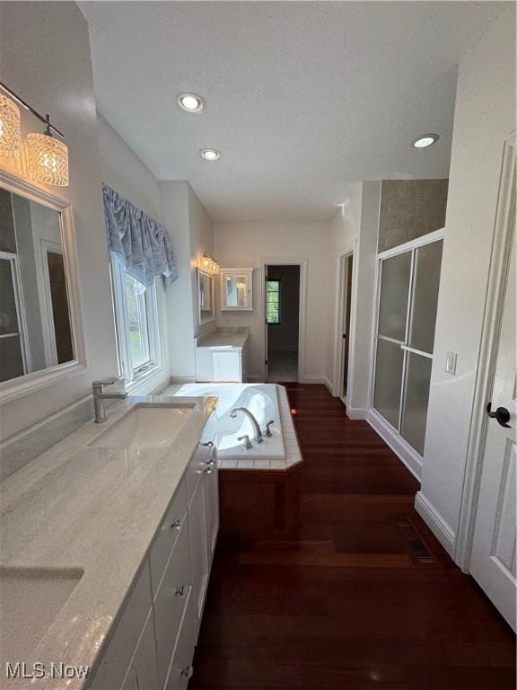 full bath with vanity, recessed lighting, wood finished floors, and a stall shower