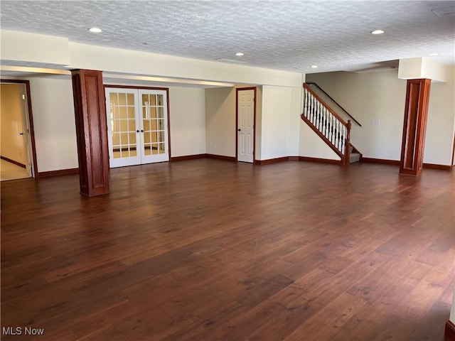 unfurnished living room featuring stairs, dark wood-style flooring, baseboards, and french doors