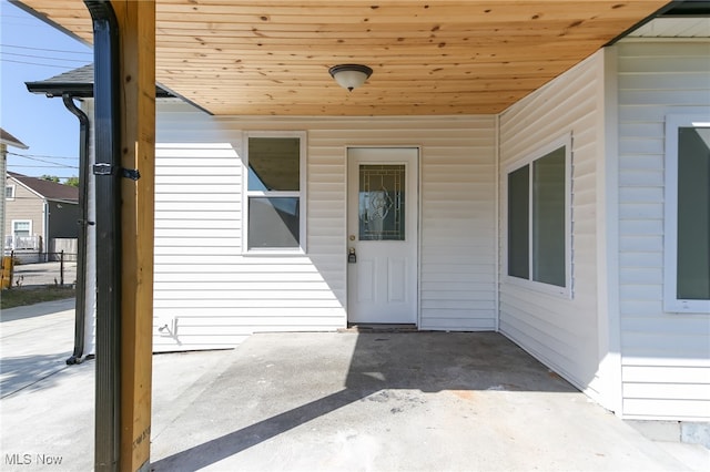 view of exterior entry with a patio area