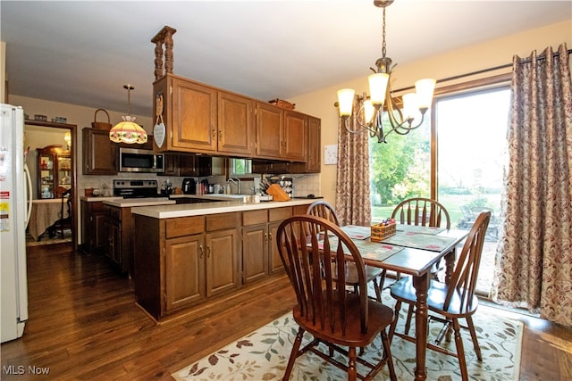 kitchen with a notable chandelier, hanging light fixtures, decorative backsplash, dark hardwood / wood-style flooring, and black / electric stove