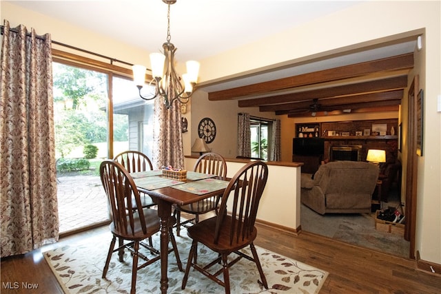 dining space featuring wood-type flooring, ceiling fan with notable chandelier, and beamed ceiling