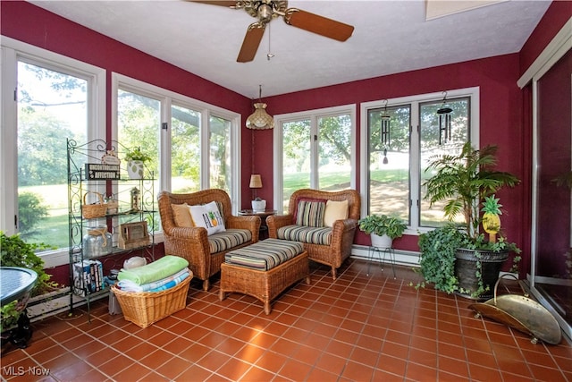 sunroom / solarium with ceiling fan and a baseboard radiator