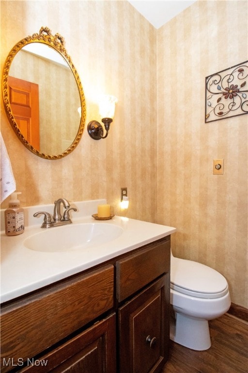 bathroom with vanity, hardwood / wood-style floors, and toilet