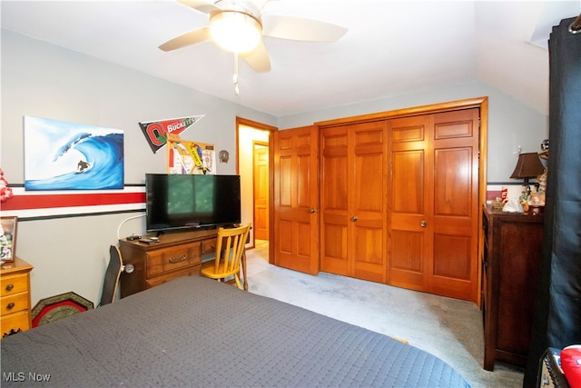 bedroom featuring vaulted ceiling, ceiling fan, light colored carpet, and a closet