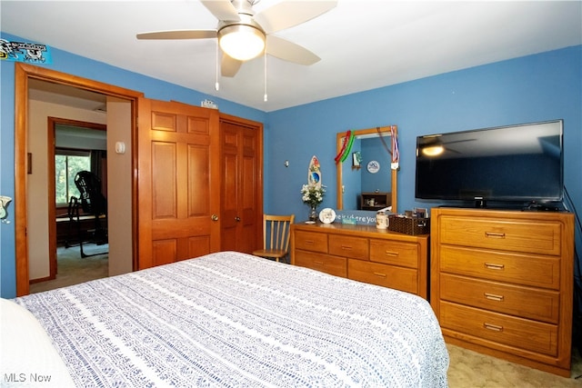 bedroom with ceiling fan, light colored carpet, and a closet